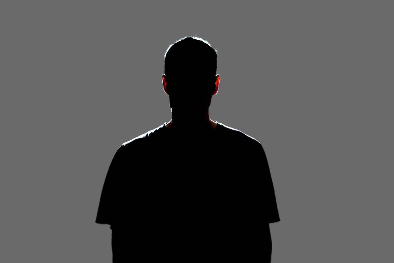 Man standing in silhouette with his back to the camera