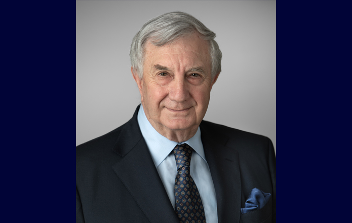Commissioner John McKechnie wearing a suit looking at the camera