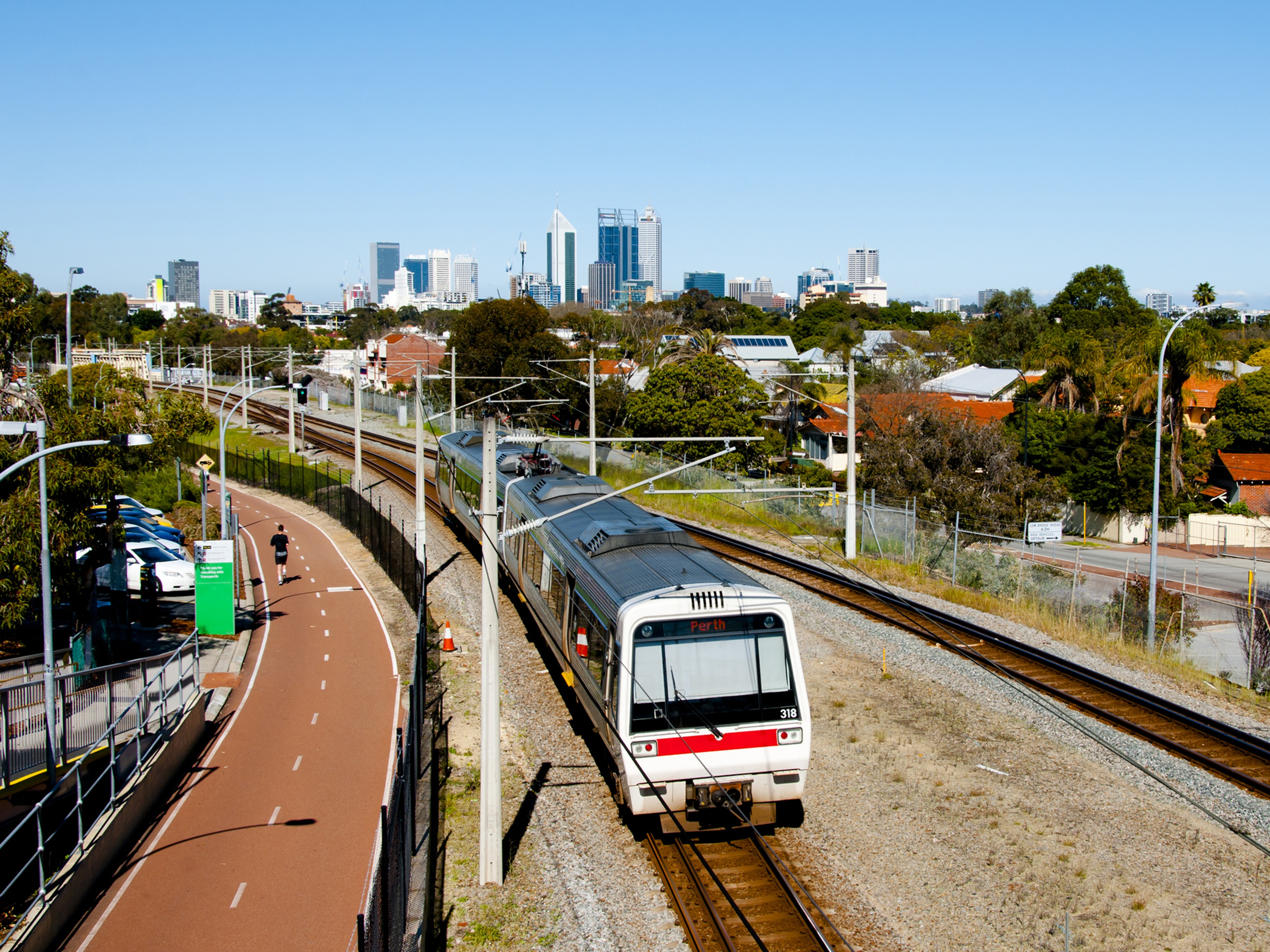 Train on train tracks with Perth skyline in background